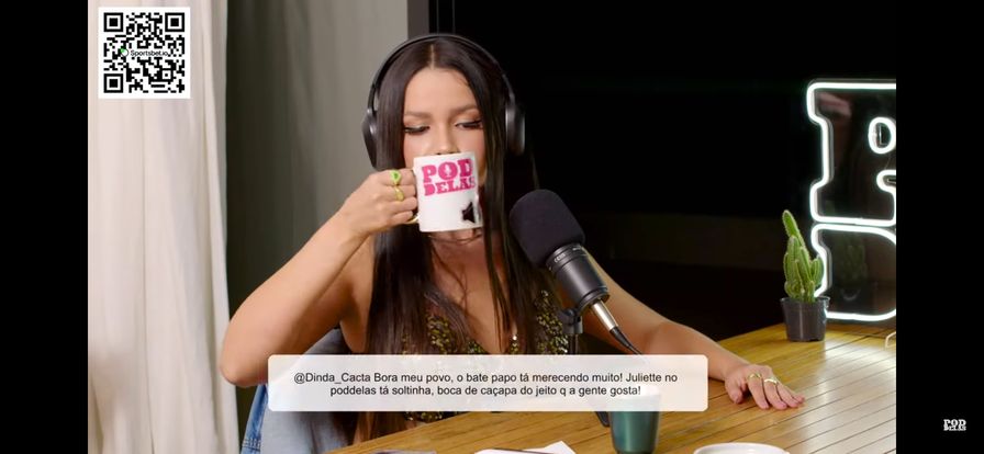Juliette no PodDelas bebendo na caneca do programa