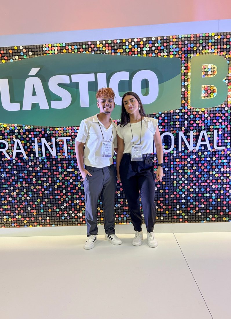 Amós e Dálet em frente ao painel da Plástico Brasil
