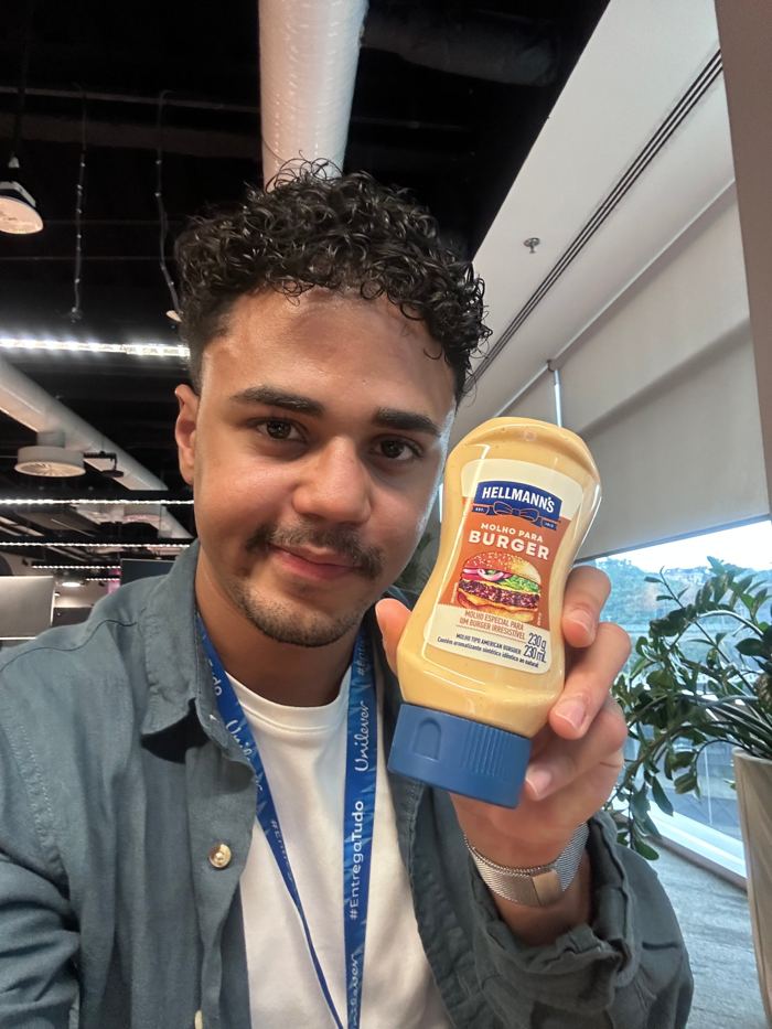 Selfie de Amós segurando o Molho para Burger da Hellmann’s no escritório